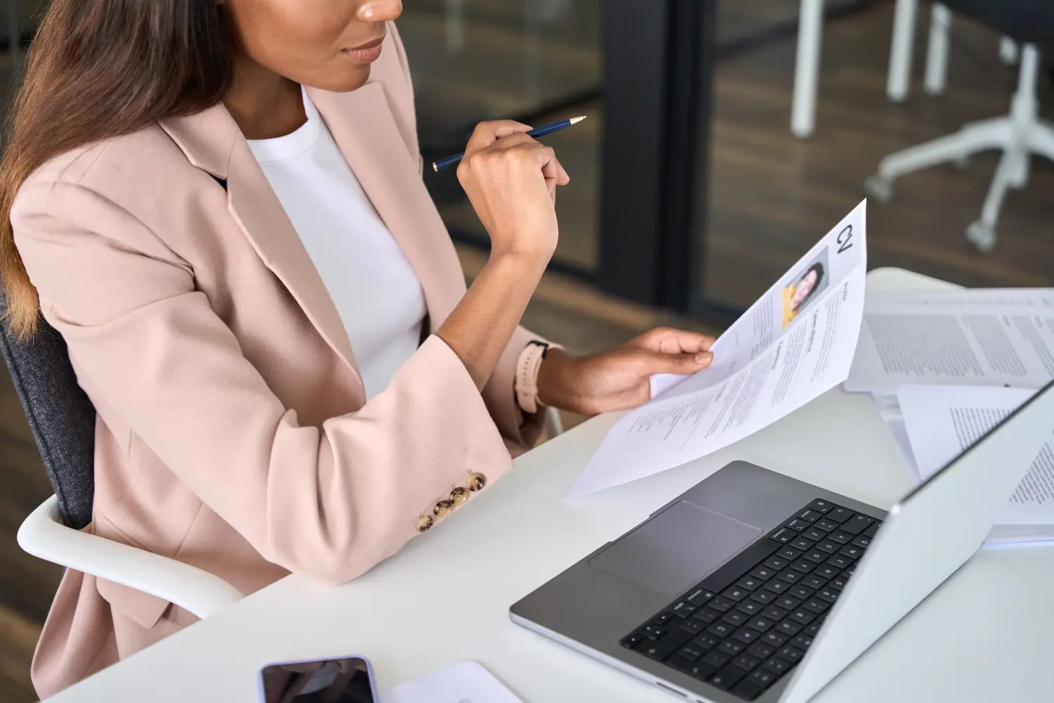 Jobway Germany - Internationale Rekrutierung von Fachkräften - Nahaufnahme einer Personalmanagerin, die während eines virtuellen Online-Vorstellungsgesprächs einen Lebenslauf liest. Geschäftsfrau hält Lebenslauf in der Hand und stellt in einer Personalagentur neue Mitarbeiter ein.
